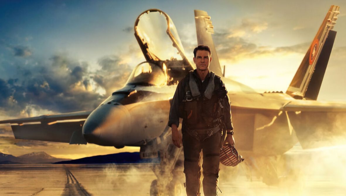 Man stood in front of a fighter jet with sunset background